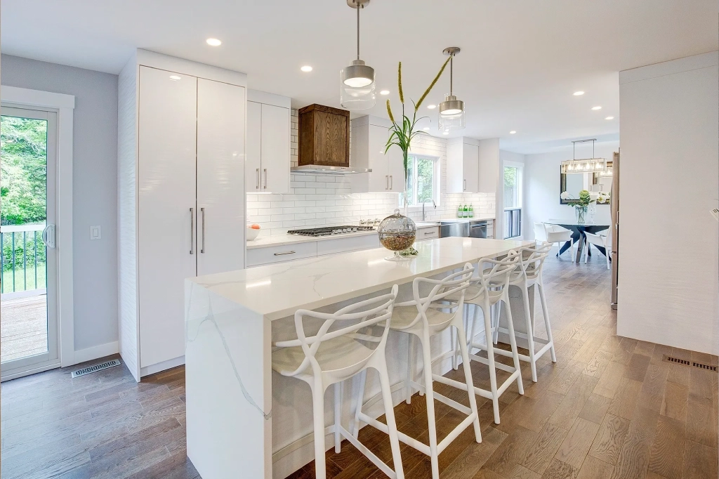 A kitchen with white counters and wooden floors.