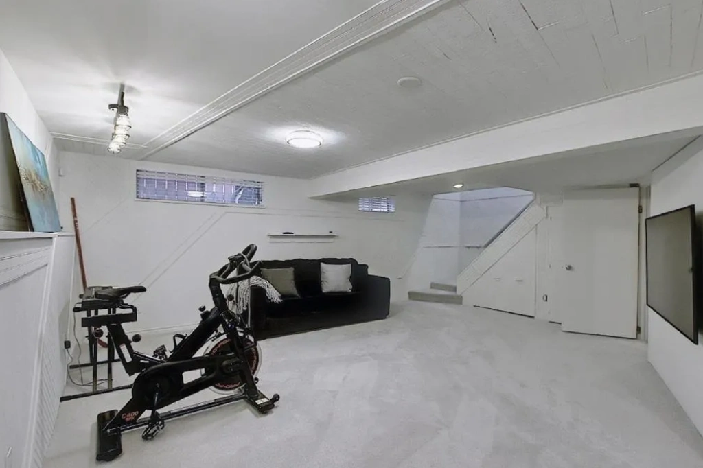 A room with a couch, sofa and exercise bike.