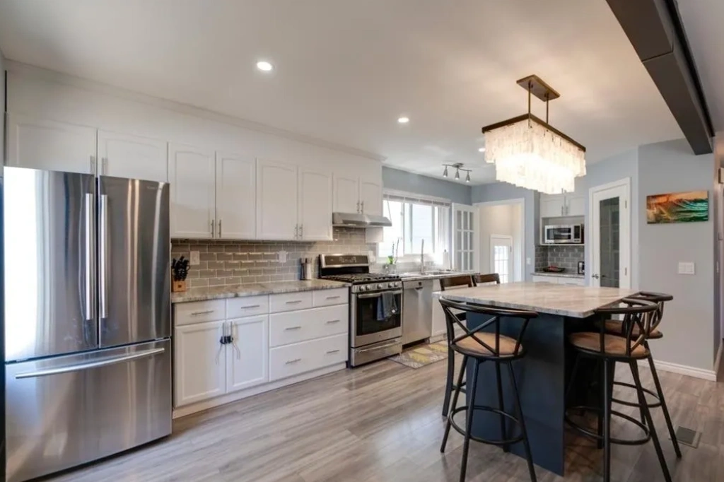 A kitchen with white cabinets and stainless steel appliances.